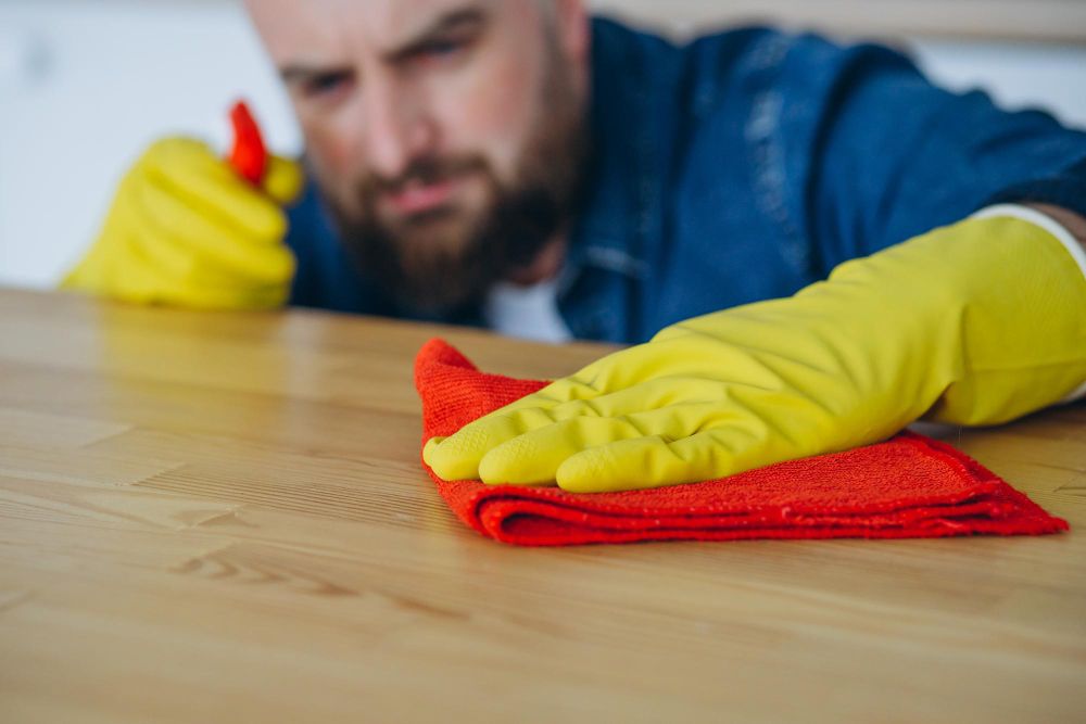 house cleaner sanitizing kitchen counters and wiping surfaces in residential home