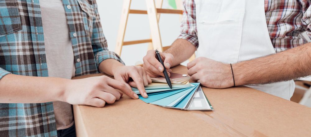 professional painter showing color swatches and company business card to customer