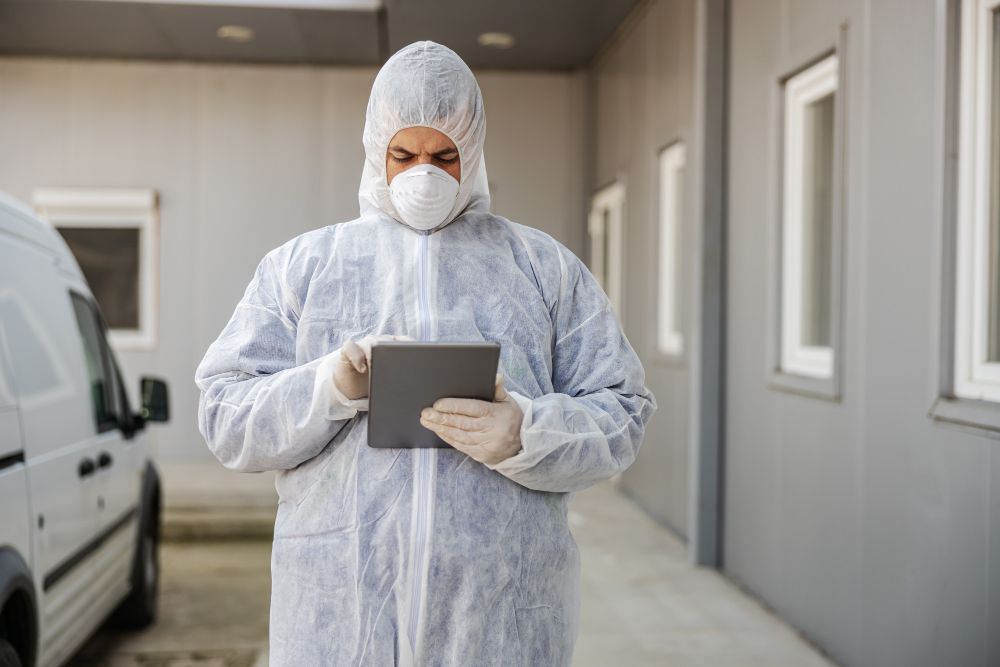 Pest control technician using a tablet during a service visit