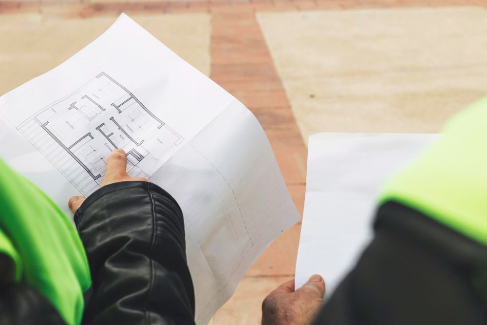plumber reviewing construction blueprints to plan plumbing installation