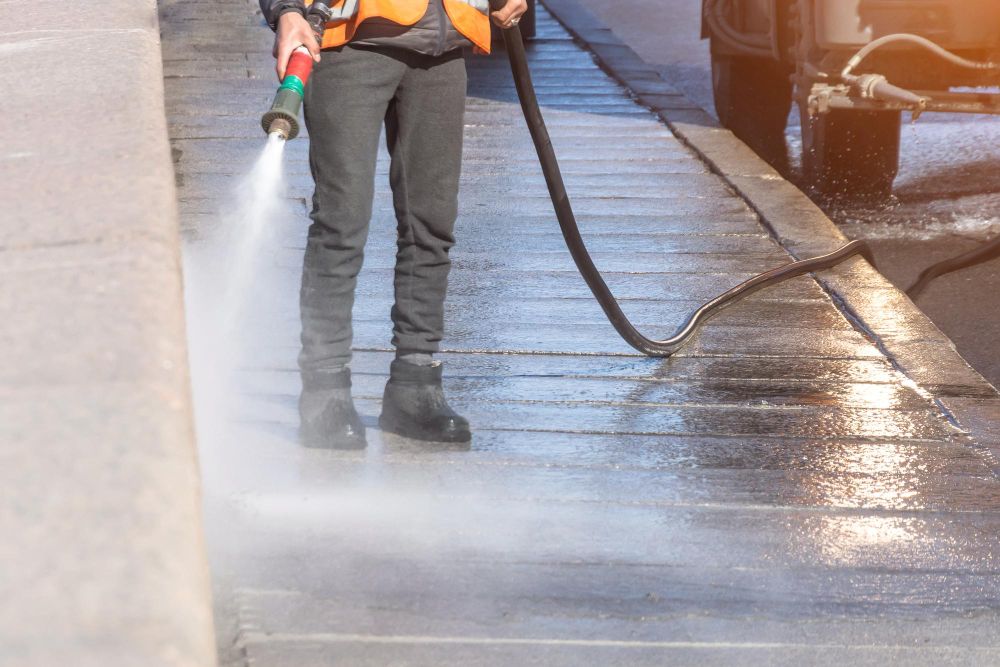 commercial pressure washing contractor cleaning storefront walls and sidewalks