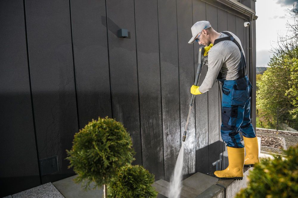residential pressure washing contractor cleaning house siding with professional equipment