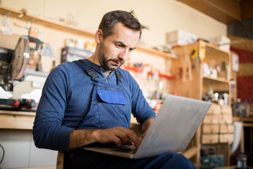 Appliance repair business owner working on a laptop