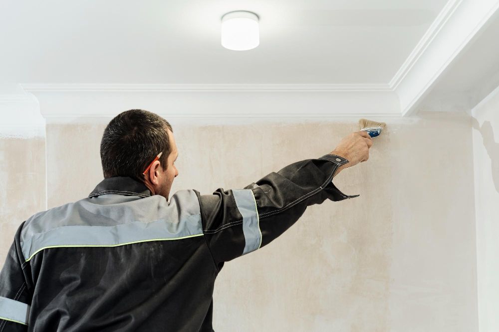 Professional painter applying primer to an interior wall
