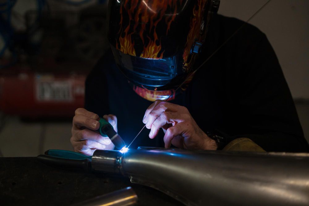 welder joining metal pipe