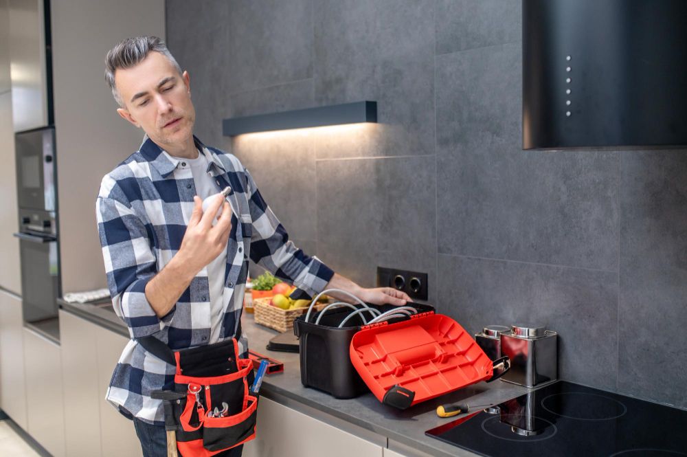 Repair technician inspecting an electrical component with tools