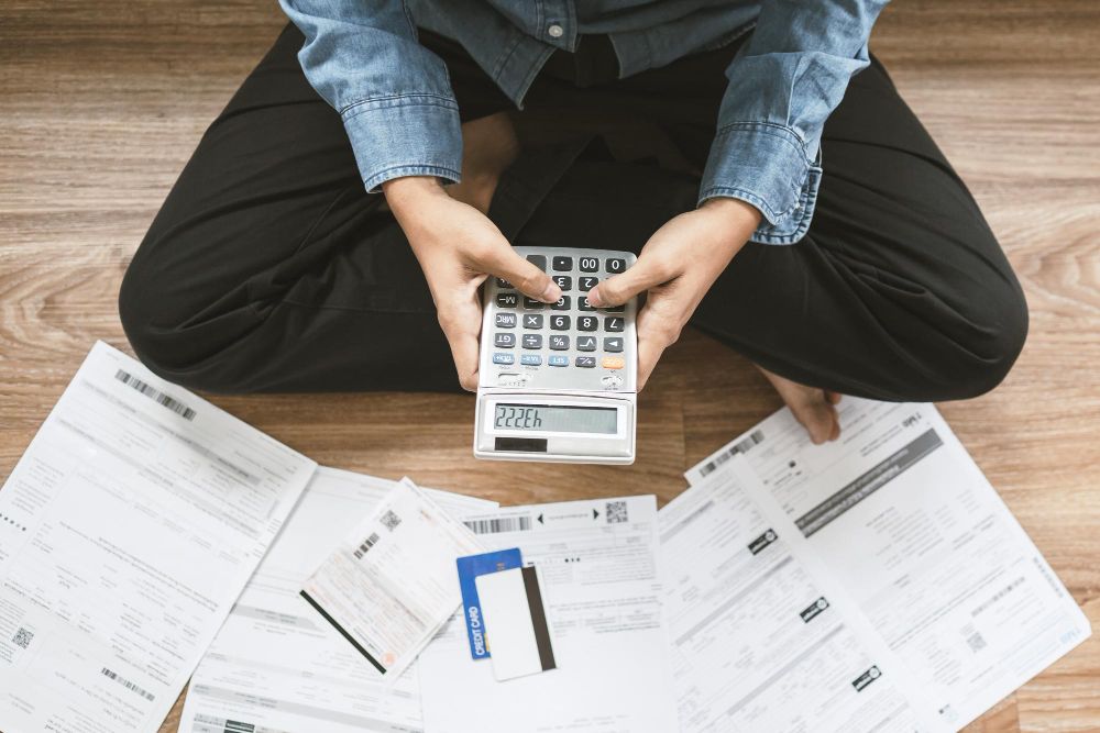 person calculating bills and financial paperwork