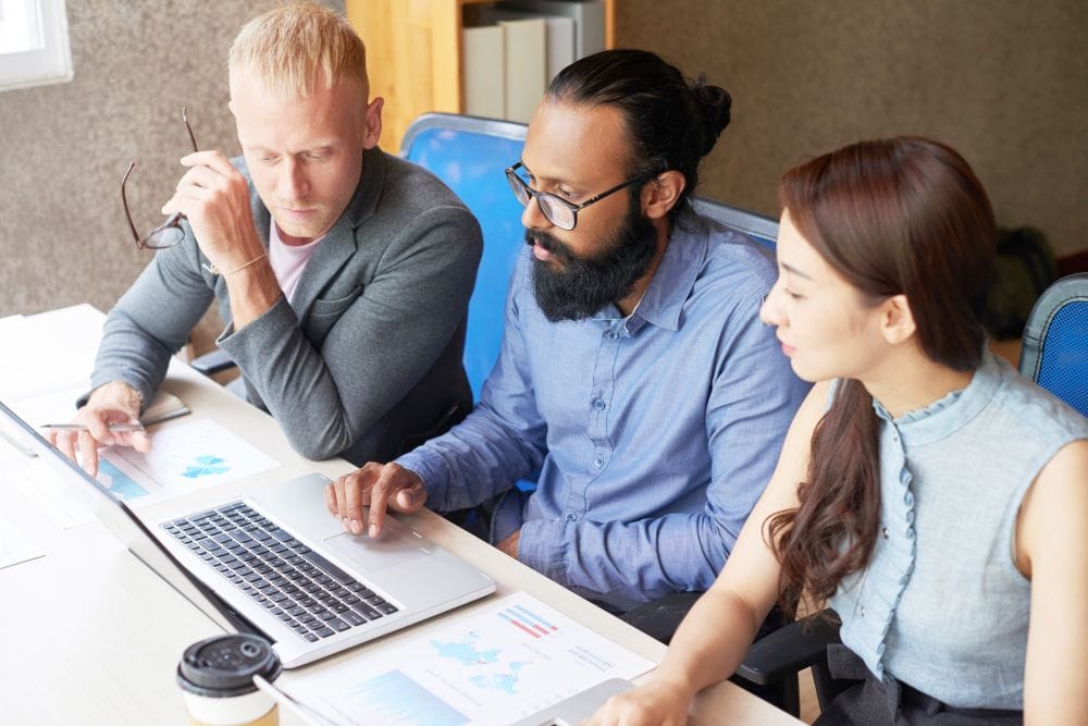 Business team reviewing project information together on a laptop