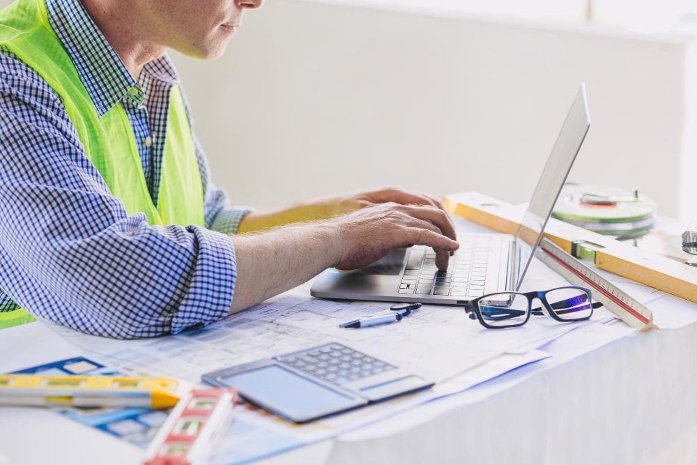 Contractor using a laptop to manage invoices and business records