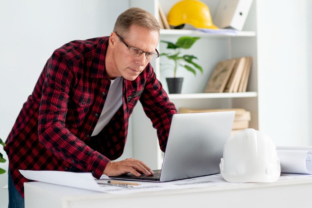 Contractor using a laptop with invoicefly vs xero to manage invoices and project records