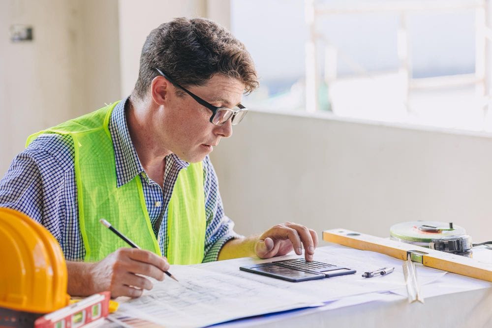 Contractor calculating construction project costs and estimates