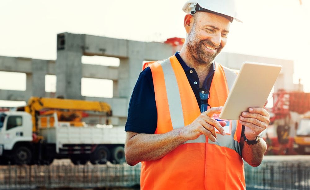 Construction professional using a tablet while managing a job site