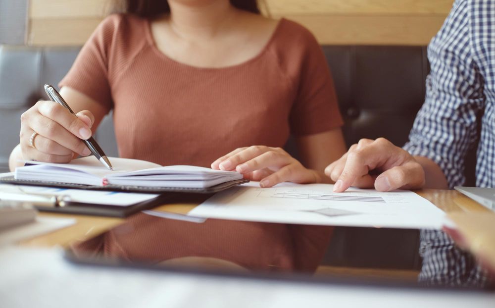 two people reviewing notes and paperwork
