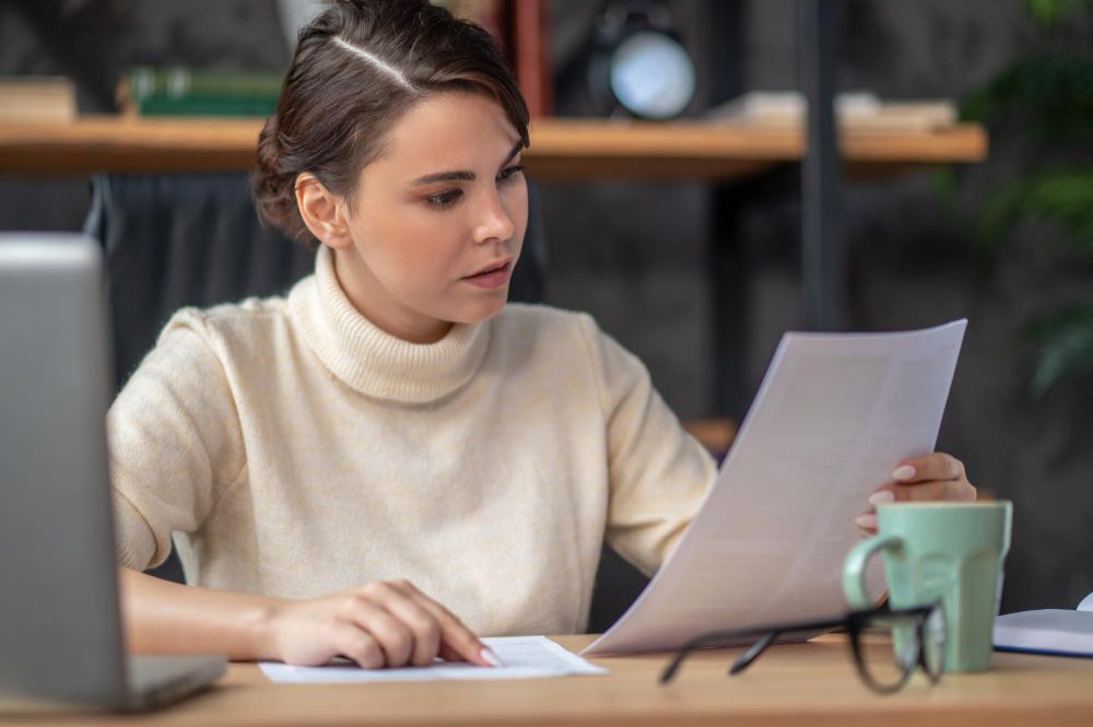woman reviewing a business document at desk