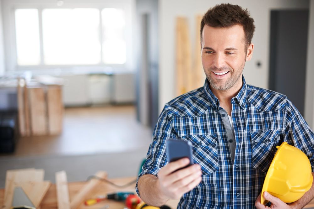 Electrician using a smartphone while working on site