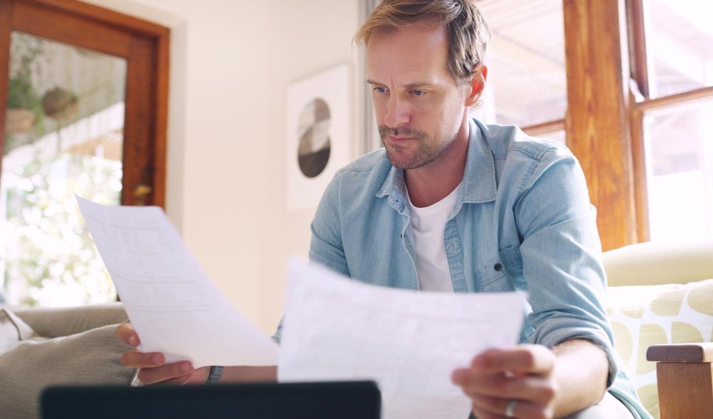man reviewing estimates and paperwork at home