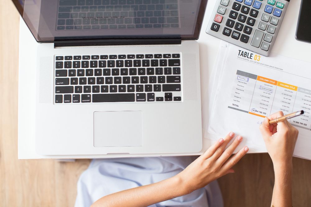 person reviewing financial report with calculator