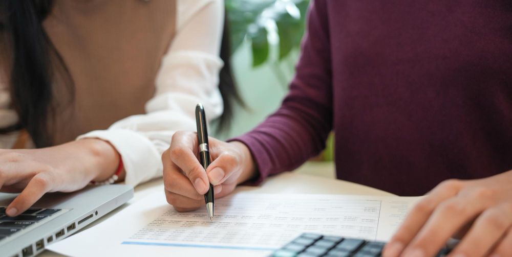 team completing financial forms at a desk