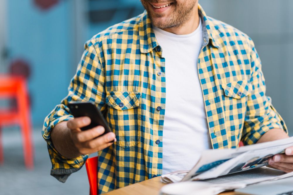 worker checking phone and printed materials