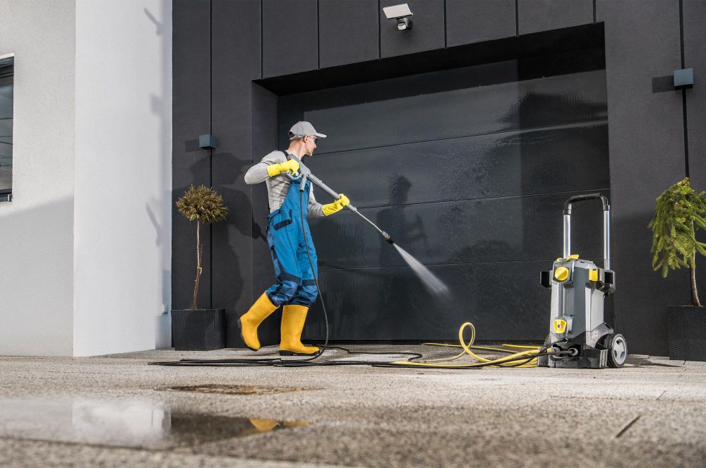Pressure washing technician cleaning a residential garage door