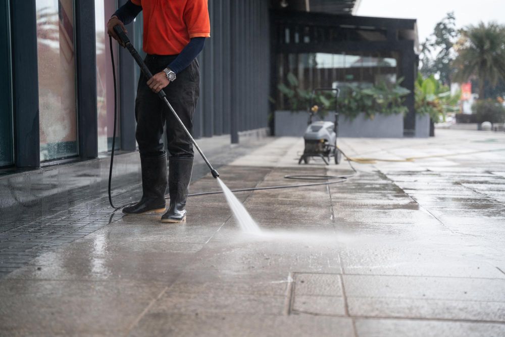 Pressure washing worker cleaning a concrete surface