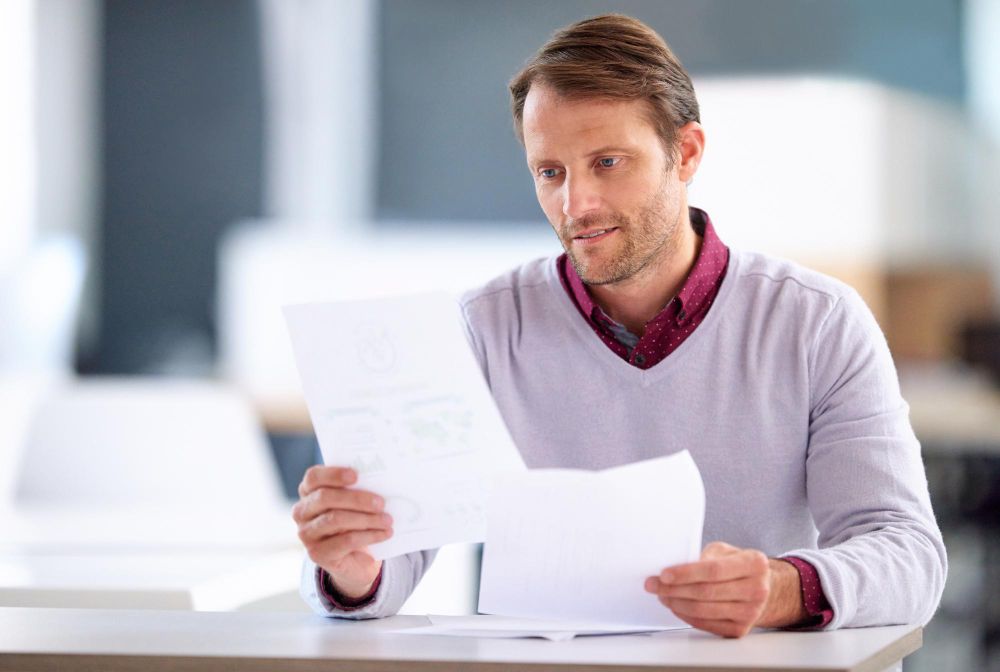 man reviewing printed invoices and documents