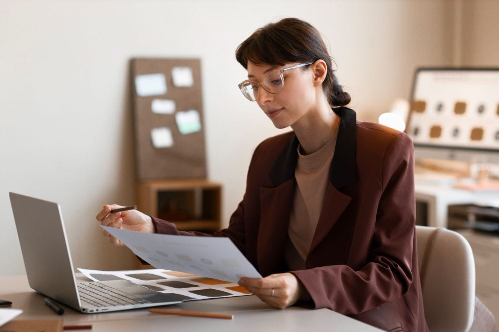 Business professional reviewing financial paperwork at a desk
