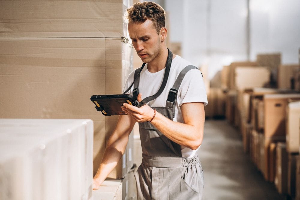 Worker managing boxes and inventory stock in a warehouse