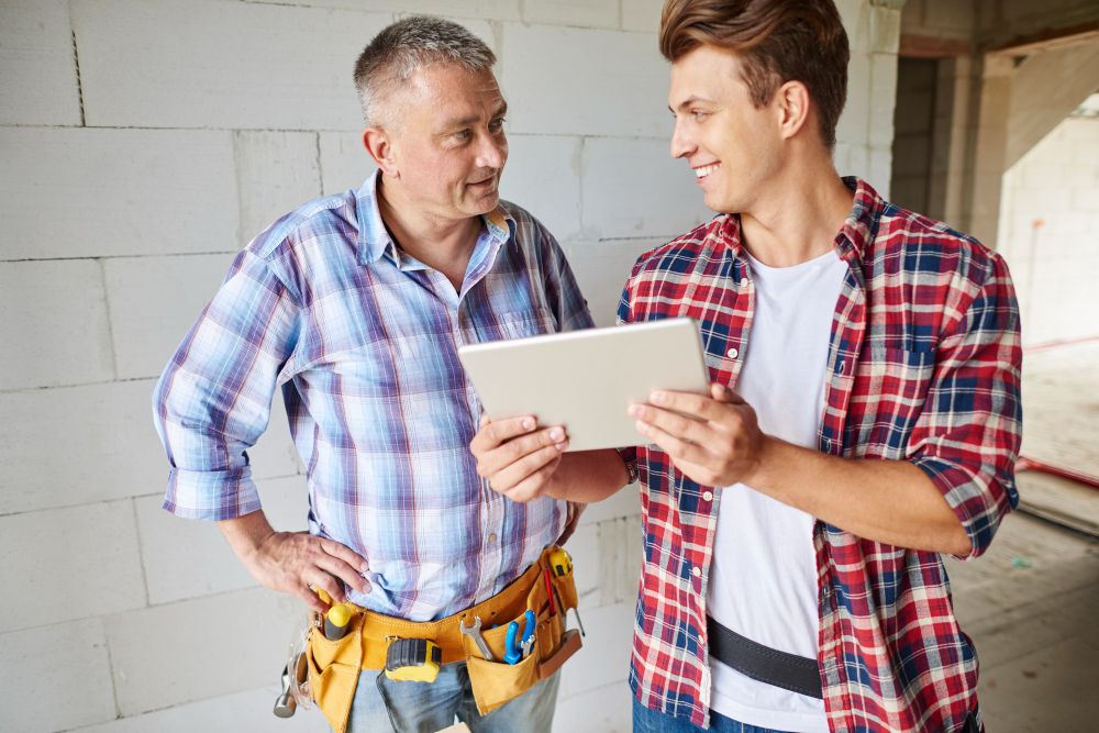 Two tradespeople reviewing job details together